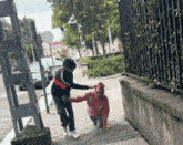 a girl in a pink sweater with smiley faces on it is helping a boy up a set of stairs