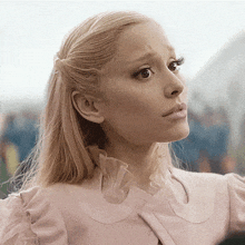 a woman with blonde hair is wearing a pink ruffled top