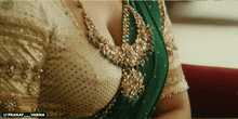 a woman wearing a green saree and a gold blouse has a watermark that says pranay_varma