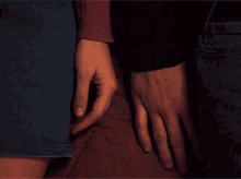 a man and a woman are holding hands and the woman is wearing a red sweater