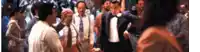 a man in a tuxedo is dancing in front of a crowd of people .