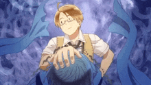 a man with glasses is holding a blue object in his hand