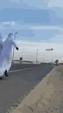 a man in a white robe is walking down a street