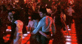 a man and a woman are dancing together on a dance floor in a crowded nightclub .
