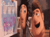 a couple of cartoon characters standing next to each other looking at a drawing .