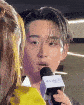 a man speaking into a microphone that says infinity on it