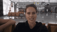 a woman is sitting in a waiting area with a sign that says ' a ' on it