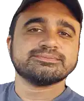a man with a beard is wearing a blue shirt and a black hat