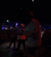 a man in a red shirt is dancing in front of a crowd