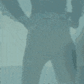 a silhouette of a man in a suit with his hands on his hips standing in front of the ocean .