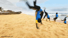 a person doing a handstand on a beach with the website www.theaurain.co.uk visible