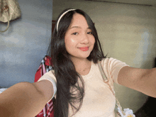 a woman taking a selfie with a white headband on her head
