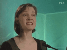 a woman singing into a microphone with yle written on the bottom of the screen