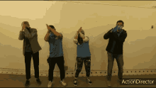 a group of people standing in front of a white wall with action director written on the bottom