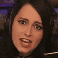 a woman is wearing headphones and making a funny face .