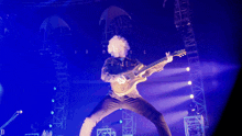 a man playing a guitar with the letter p visible