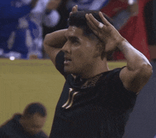 a man in a black shirt with a gold letter j on it