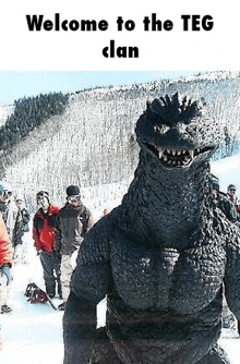 a giant godzilla is standing in the snow next to a group of people .
