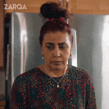 a woman standing in front of a fridge with the word zarqa on the bottom