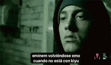 a black and white photo of eminem wearing a hooded jacket and a beanie .