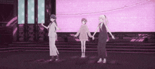 three anime girls are dancing on a stage in front of a large screen .