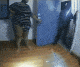 a woman in a striped shirt stands in front of a door
