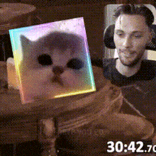 a man is sitting at a table with a picture of a cat in a cube
