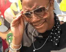 a woman wearing sunglasses and a polka dot scarf