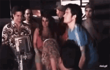 a group of people are standing around a camera while a man talks to a woman .