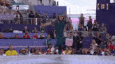 a woman dancing in front of a crowd at the olympics