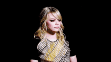 a woman with blonde hair is wearing a black and white striped shirt .