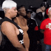 a group of people are standing in a room and one of them is wearing a red shirt that says rip ea .