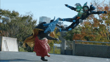 a man in a red cape is standing next to a man in a green armor
