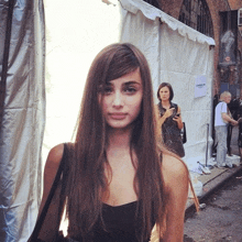 a woman stands in front of a white tent with a sign on it that says ' givenchy ' on it