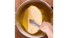 a person is using tongs to stir food in a pot of liquid