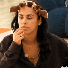 a woman wearing a headband with giraffe ears and a necklace with the letter y on it