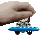 a hand is holding a small doll on top of a blue keyboard .