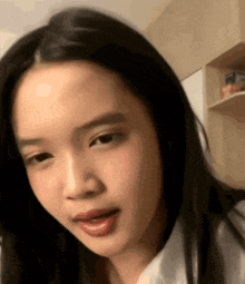 a woman with long black hair is making a funny face