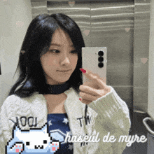 a woman taking a picture of herself in a mirror with the words haseul de myre on the bottom right