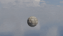 a statue of a monkey holding a stone ball in the air