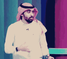 a man with a beard wearing a head scarf and a microphone on his neck