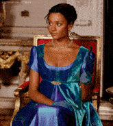 a woman in a blue and purple dress is sitting in a chair with mistressvera tumblr written below her