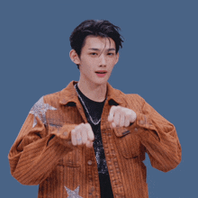 a young man wearing a brown striped jacket and a black shirt