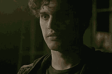 a close up of a man 's face in the dark with a serious look on his face .