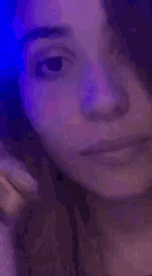 a blurry picture of a woman eating food in a dark room with blue lights behind her