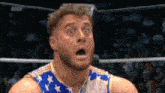 a wrestler with a surprised look on his face is wearing a shirt with stars and stripes