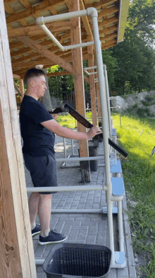 a man in a black shirt holds a shotgun in his hand