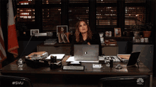 a woman sitting at a desk with a laptop and a name tag that says capt. olivia brown