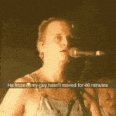 a man singing into a microphone with the words he froze my guy hasn 't moved for 40 minutes