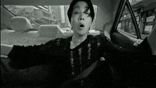 a man is sitting in the back seat of a car .